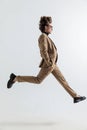 Cool side view picture of young man jumping in the air with hands in pockets Royalty Free Stock Photo