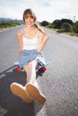 Cool skater girl doing sitting on her skateboard