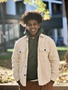 Cool smiling young African American guy standing at big city sunny street. Royalty Free Stock Photo