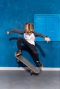 Cool stylish boy skateboarder levitating in jump on longboard.