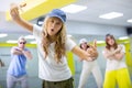 Cool talented teens in casual wear exercising modern dance moves in training room