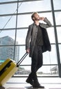 Cool travel man walking with mobile phone and suitcase Royalty Free Stock Photo