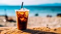 Iced coffee sits enticingly on a cafe table with a beach backdrop Royalty Free Stock Photo