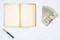 Money, notebook and pen with white background. Isolated Royalty Free Stock Photo