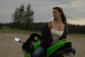 Cool woman in helmet on motorbike on beach