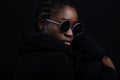 Cool woman sitting with dark skin wearing round sunglasses Royalty Free Stock Photo