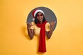 Cool young African woman in Santa Claus hat, red scarf and sunglasses doing phone gesture call me back with hand and fingers like Royalty Free Stock Photo