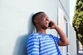 Cool young black guy laughing and talking on cell phone Royalty Free Stock Photo