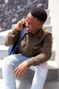 Cool young black guy laughing and talking on mobile phone Royalty Free Stock Photo