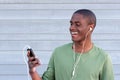 Cool young black guy smiling with MP3 player and earphones Royalty Free Stock Photo