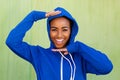 Cool young black woman smiling with hands raised