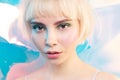 Cool young blond girl with glowing skin, plump moistened lips, perfect modern make up