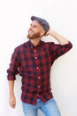 Cool young man with beard smiling against white wall Royalty Free Stock Photo