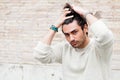 Cool young man fashion model, hairstyle. Hand in the hair Royalty Free Stock Photo