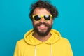 Cool young man in yellow hoodie wearing sunglasses and smiling Royalty Free Stock Photo