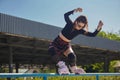 Inline roller blader female performing a miszou grind trick on a rail in a skatepark. Cool young skater person skating outdoor in Royalty Free Stock Photo