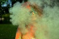 Cool young model having fun in a cloud of green dry powder, celebrating Holi colors festival Royalty Free Stock Photo