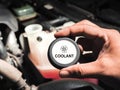 Mechanic hand opens car radiator cap to inspect and add coolant in a car engine compartment. Royalty Free Stock Photo