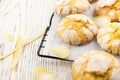 Cooling rack with delicious lemon cookies and citrus peels on white wooden table , closeup