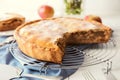 Cooling rack with freshly baked tasty apple pie on table