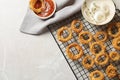 Cooling rack with homemade crunchy fried onion rings and sauces on light background, top view Royalty Free Stock Photo