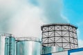 Cooling tower, desuperheater, smoke from a pipe of an industrial plant or thermal power plant on a background of blue sky Royalty Free Stock Photo