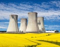 Cooling tower with golden flowering field of rapeseed