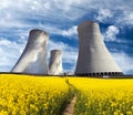 Cooling tower with golden flowering field of rapeseed