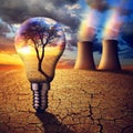 Cooling towers of a nuclear power plant and light bulb in a devastated dry landscape. Royalty Free Stock Photo