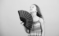Cooling and ventilation. Summer heat. Fresh air. Kid girl fanning herself with fan. Conditioning system. Climate control Royalty Free Stock Photo