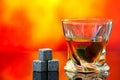 Cooling whiskey stones with twist whiskey glass against abstract background