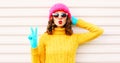 Cooll funny girl blowing red lips wearing colorful knitted yellow sweater pink hat