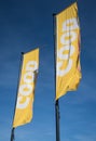 Coop food grocery store flags with branding and logo against a blue sky