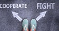 Cooperate and fight as different choices in life - pictured as words Cooperate, fight on a road to symbolize making decision and