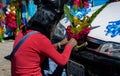 Unidentified woman decorates a car with a bouquet for the religious tradition of blessing cars in Copacabana, Bolivia