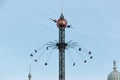 Amusement park carousel at the top with people enjoying the attraction in Copenhagen`s