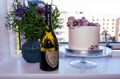 Birthdag cake decorated with pink flowers and a bottle of vintage French champagne Don Perignon