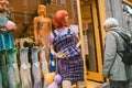 A random woman next to a mannequin at a shop