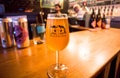 Craft beer bar with glass of popular danish beer by Mikkeller brewery, in special designed glass