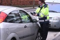 FEMALE PARKING INSPECTOR GIVES PARKING FINE TICKET Royalty Free Stock Photo