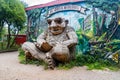 Wooden monkey sculpture in Freetown Christiania with the inscription The world is in our