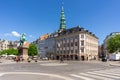 Busy city street in downtown Copenhagen on a beautiful summer day with the Danish king`s statue in the center