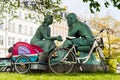 Wheelbarrow cargo bike standing near sculpture Royalty Free Stock Photo