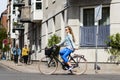 Woman riding bicycle showing left turn signal. Street style Royalty Free Stock Photo