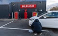 Man inflates tire with air and checking air pressure with gauge pressure in service station. Flat tire concept Royalty Free Stock Photo