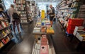 Bookstore customers leaf through new fiction books inside modern bookshop Royalty Free Stock Photo