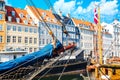 Copenhagen iconic view. Famous old Nyhavn port in the center of Copenhagen, Denmark during summer sunny day with a boat on the Royalty Free Stock Photo