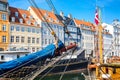 Copenhagen iconic view. Famous old Nyhavn port in the center of Copenhagen, Denmark during summer sunny day with a boat on the Royalty Free Stock Photo