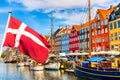 Copenhagen iconic view. Famous old Nyhavn port in the center of Copenhagen, Denmark during summer sunny day with Denmark flag on