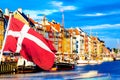 Copenhagen iconic view. Famous old Nyhavn port in the center of Copenhagen, Denmark during summer sunny day with Denmark flag on Royalty Free Stock Photo